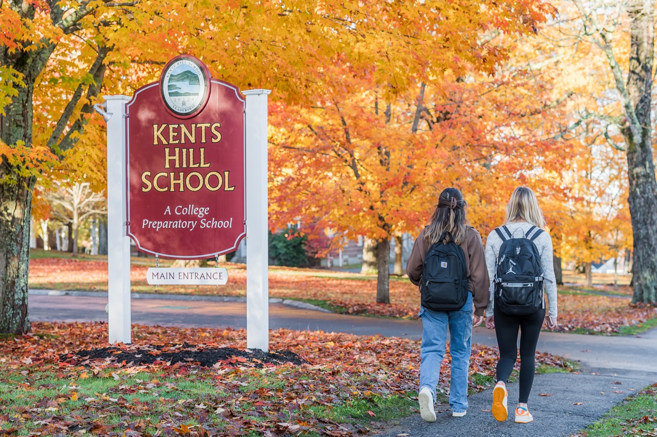 students walking by school sign
